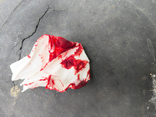 Crumpled bloody tissue paper on the ground concept murder, crime, accident, incident, emergency