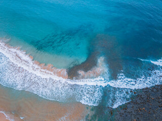 Top down at the seaside with waves, rocks and seaweed © Merrillie