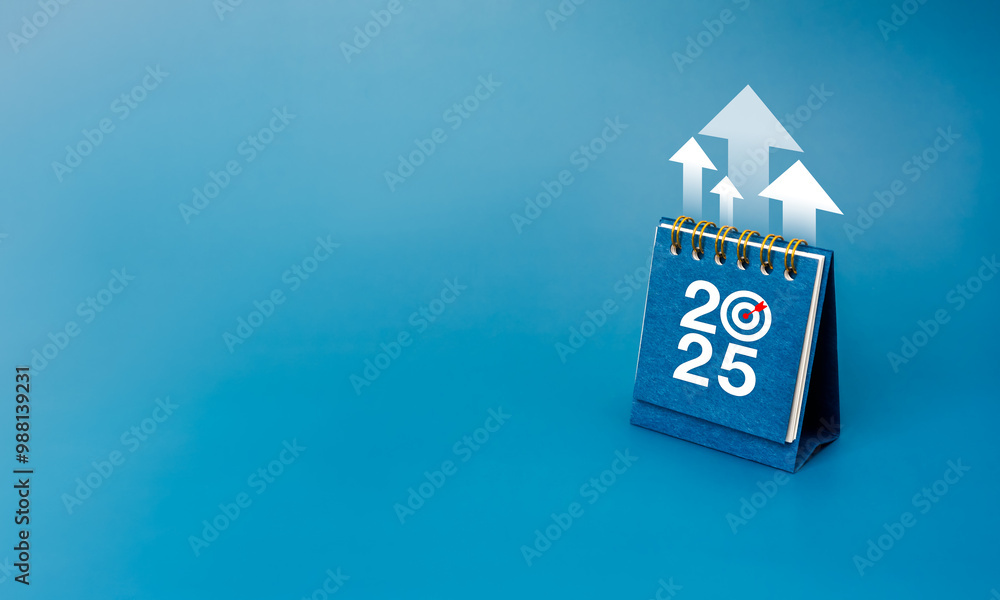 Wall mural Happy new year 2025 background. White rising arrows up on 2025 desk calendar cover standing on blue background with copy space, minimalist. Business plan agenda, goal and success concept.