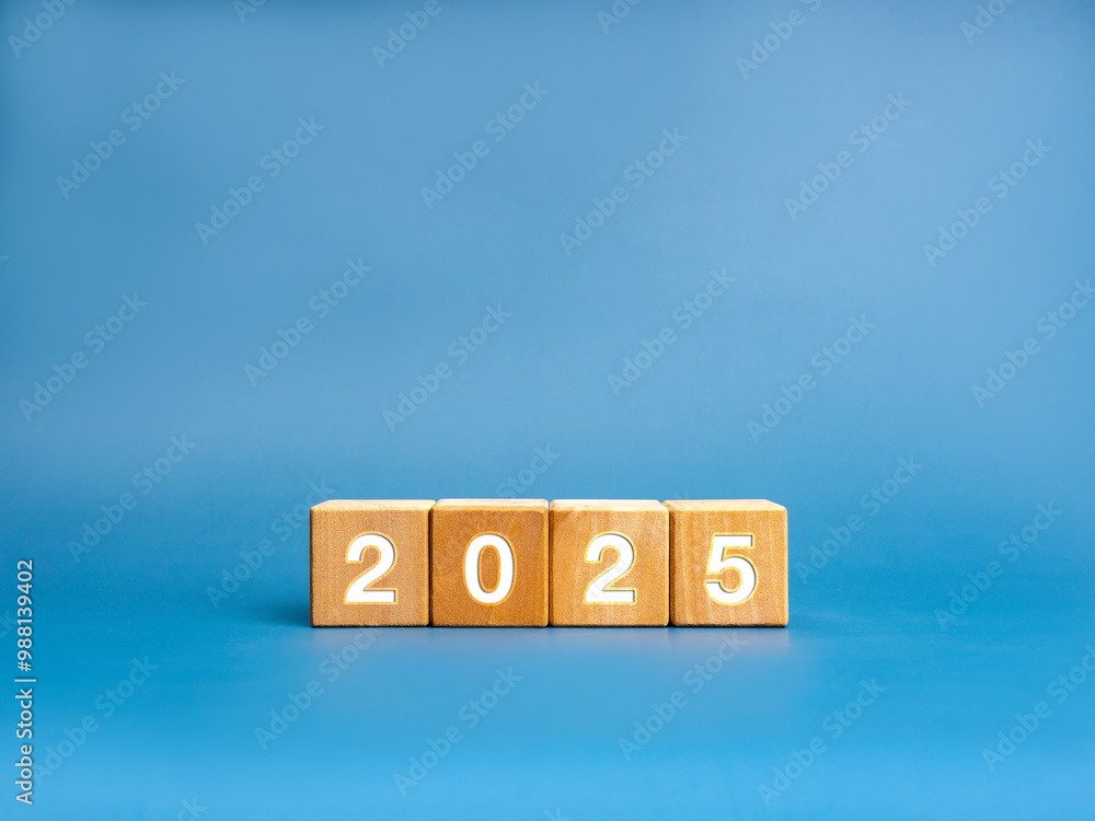 Sticker Happy new year concept. Wooden cube blocks with white 2025 calendar numbers isolated on blue background with copy space. Business growth and success banner eco style.