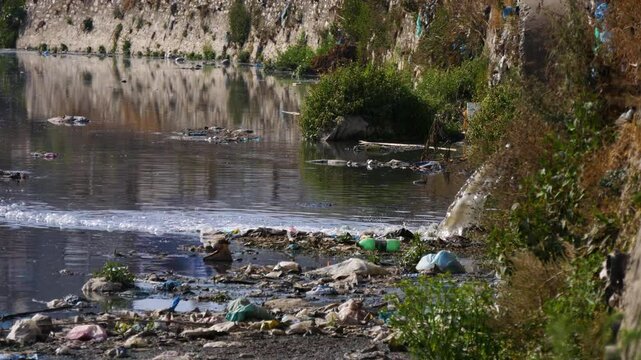 Draining city sewage into river resulting water pollution and lots of plastic pollution in river.