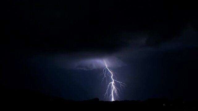 Thunderstorm flashes with multiple bolts of lightning on dark cloudy sky
