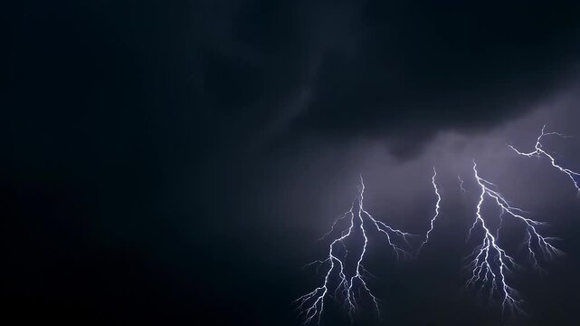 Thunderstorm flashes with multiple bolts of lightning on dark cloudy sky