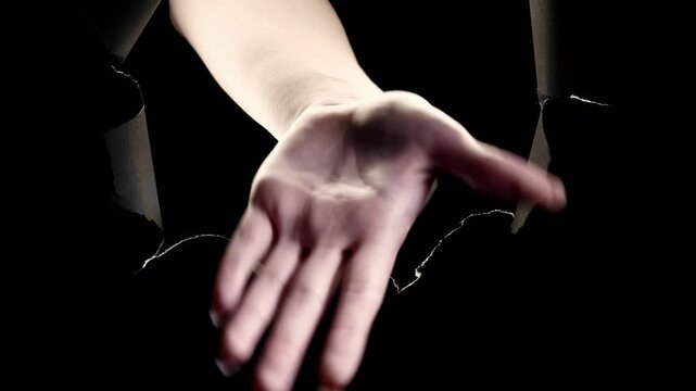 Vertical video. So-so gesture. Clueless answer. Confusion doubt. Female hand waving inside black breakthrough paper hole torn wall on dark night free space background loop.