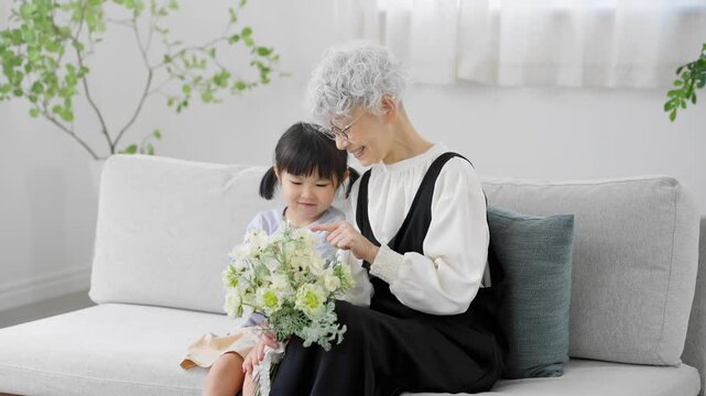 花束を持った孫と祖母　ファミリーイメージ	
