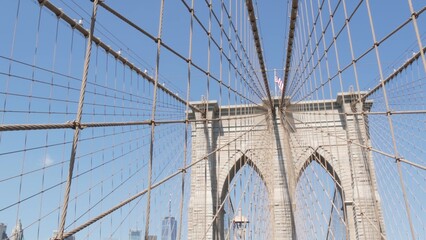 Obraz premium Brooklyn Bridge to Manhattan downtown, cables and blue sky. New York City iconic symbol, USA travel destination. Architecture of United States of America, tourist landmark. Famous cable-stayed bridge.