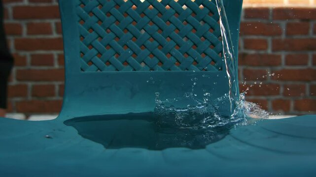 Super Slowmotion Shot of Water Whirling on Garden Chair Bottle at 1000fps.
