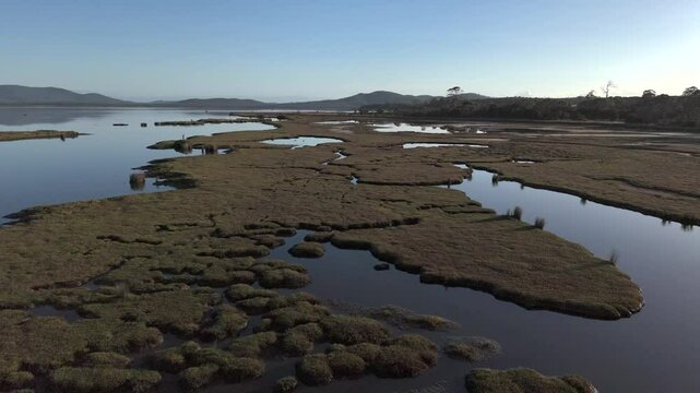 Mudflat at surface of water of Moulting lagoon in coles bay, tasmania, australia, aerial shot