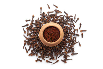 A mud pot filled with organic Clove (Syzygium aromaticum) or Indian long powder, placed on a heap of Clove buds, isolated on a white background.