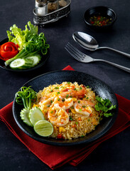 Shrimp fried rice Inside the black plate on the black stone table