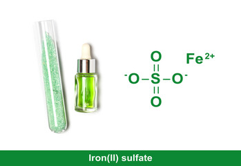 Ferrous Sulfate in test tube with chemical structure place next to Iron (II) sulfate liquid in dropper bottle. Closeup chemical ingredient on white laboratory table.