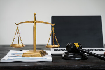 A lawyer's desk in an office,with legal documents, computers, and hammers placed neatly.The setting...