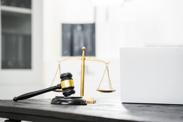 A lawyer's desk in an office,with legal documents, computers, and hammers placed neatly.The setting is organized for legal consulting services, contract reviews,will drafting,document certification