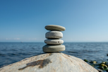 Pieces of craft soap in the shape of stones are stacked on top of each other against the background of the sea or lake. Image of organic cosmetics in a natural environment