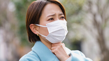 マスクをした体調不良の女性（冬服・上着・コート）