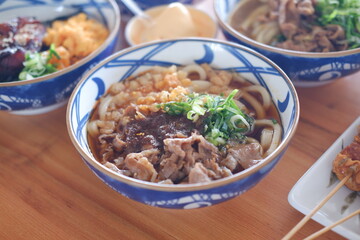 Rice noodle with beef in bowl on wooden table background.