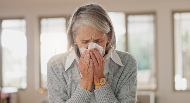Senior woman, tissue and blowing nose in home, sick and retirement with flu, cold or sinus in morning. Elderly person, paper and cleaning for hygiene, allergies or sneeze with hay fever at apartment