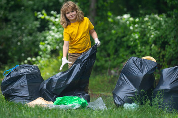 Child boy picking up plastic bottle outdoor. Save environmental and reduce waste concept. Recycle waste, litter rubbish garbage trash junk clean. Ecology concept. Environment plastic pollution.