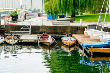 Obraz premium voyageur canoes in urban harbor shot downtown toronto in fall with city park in background