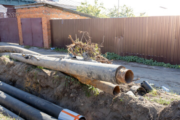 A pile of pipes and a fence in front of a house