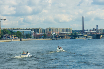 Two boats are on the water, one of which is a pontoon boat