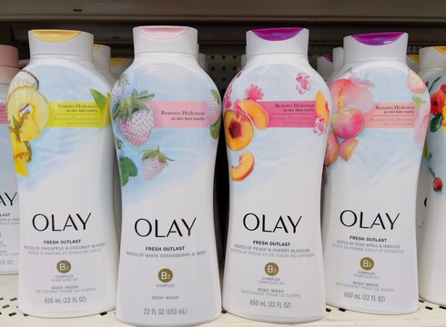 Big bottles of Olay body wash in various scents on the market shelf.