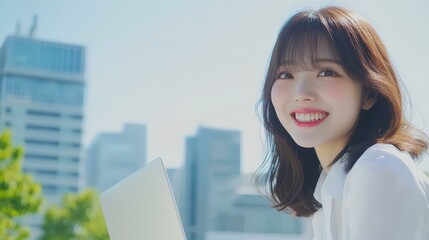 A joyful Japanese woman web designer works on her laptop, showcasing creativity and passion for design through her craft.