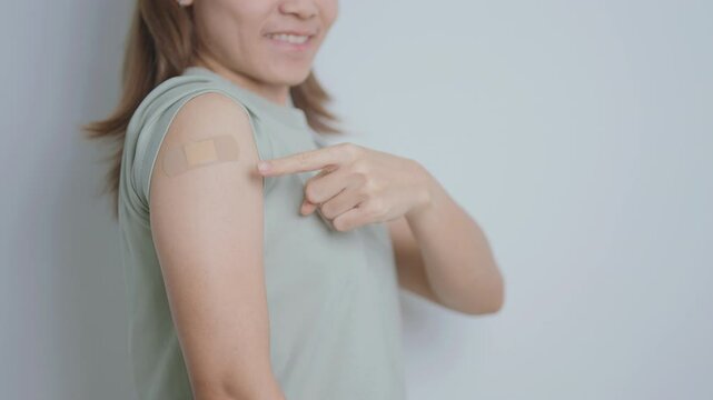 Woman with bandage after receiving vaccine. Vaccination and Immunization for Influenza, HPV, Zoster, IPD, DTP or Diphtheria, Tetanus and Pertussis, MMR, Hepatitis B, Covid  and Varicella vaccine