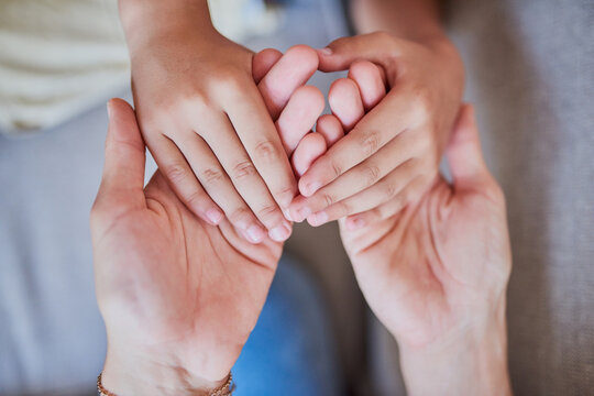 Love, above and parent holding hands with child for respect, kindness and support in growth. Home, bonding and person with gesture of care to kid for connection, safety and guidance in development