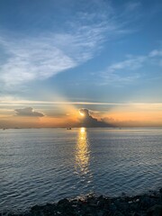 Obraz premium Sunrise Over Calm Sea with Dramatic Sky and Cloud Reflection.