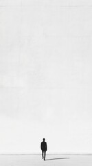 A lone figure stands against a vast, blank background, evoking feelings of solitude and introspection in a minimalist landscape.