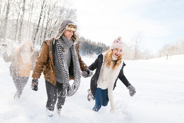 Friends in snowball fight in snowy nature. First snowfall of the season.