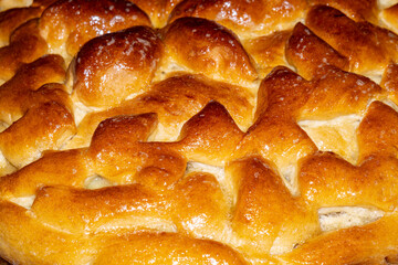 Close-up food photography of baked decorative yeast dough pie in a round shape.