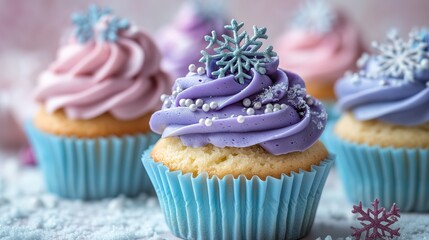 cupcakes with blue and purple frosting, topped with snowflake decorations, set against a pastel background