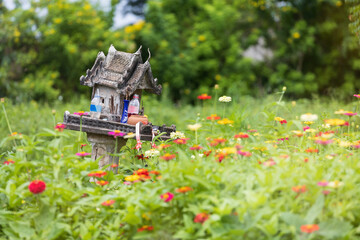 Old spirit house for guardian spirit to reside for protective spirit of a place on flower field...