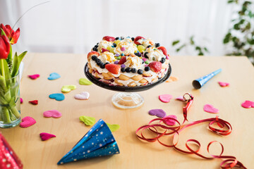 Homemade birthday cake with fresh fruits on cake stand. Birthday party.