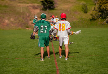 Two lacrosse players from the opposing teams waiting for play to begin