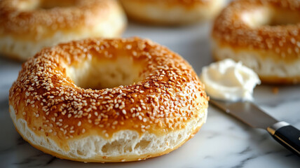 Sesame bagel with cream cheese on a marble surface.