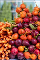 A vibrant display of fresh beets and carrots at a farmers market