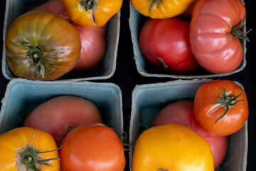 A variety of colorful heirloom tomatoes displayed in cartons