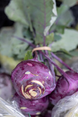 Close-up of purple kohlrabi with leaves at a farmers market
