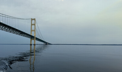 View of Mackinac Bridge stretching over calm water, with reflection