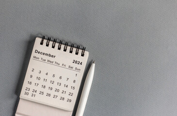 Monthly desk calendar for December 2024 on a gray background.