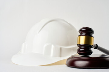 Labour laws labour code or employment laws concept. Safety hard hat and judge gavel on a gray...