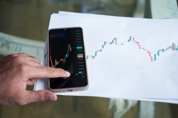 Indian stock market trader investor broker trading in smart phone, analyzing price in mobile exchange app. Investor.