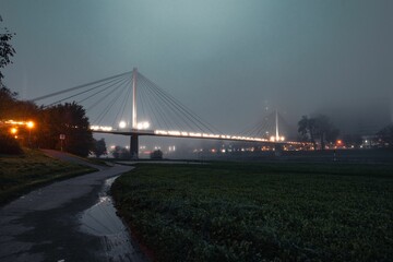 a road running by some water with lights on it in the background