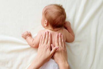 Chiropractic manual therapist manipulating child's back baby girl receiving massage therapy ensuring his delicate muscles receive proper care and relaxing treatment at home