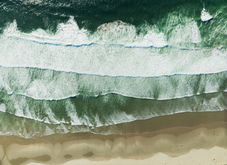 The ocean waves are crashing against the shore, creating a beautiful