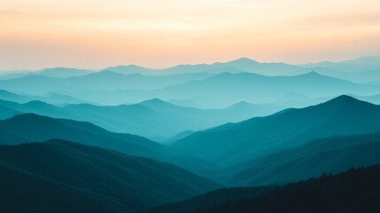 Fototapeta premium Sunset over distant mountains with layered blue hues and soft twilight colors in a serene landscape