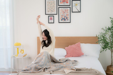A beautiful woman wakes up in her bed. Her dress looks soft and comfortable.
